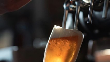 Why do bartenders wet the glass before serving the beer?