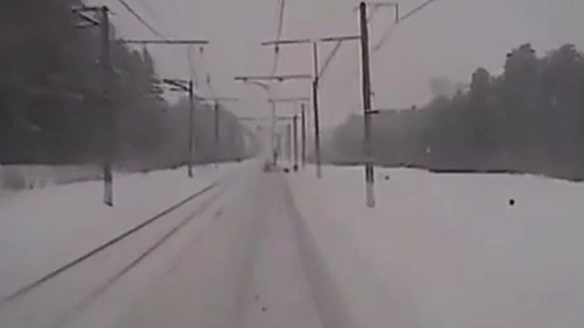 Des employés travaillent sur une ligne de chemin de fer quand un train arrive