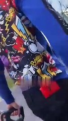 2 hommes découpent le pot catalytique d'une voiture en pleine journée à Paris