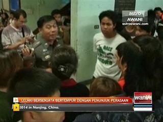 Lelaki bersenjata bertempur dengan penunjuk perasaan