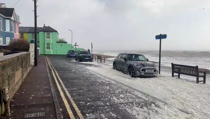 Cars along Dover seafront covered in spray