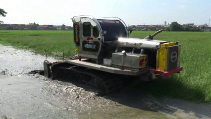 Tractor plowing rice field in Thailand