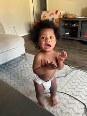 Baby Playing with Vacuum Puts Hose to Face