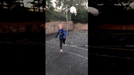 Kid Kicks a Soccer Ball into a Basketball Hoop