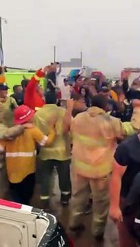 Bomberos y brigadistas festejando la llegada de la lluvia a Corrientes
