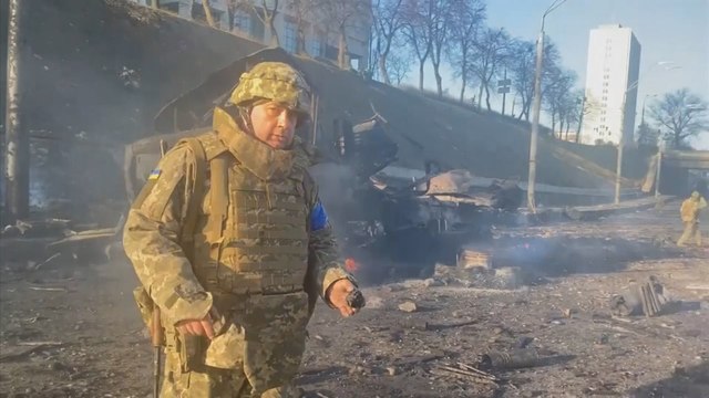 Ukrainian soldiers inspecting wreckage from overnight fighting in Kyiv