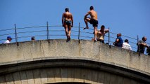 Two bridge divers standing on the top of the Old Bridge in Mostar