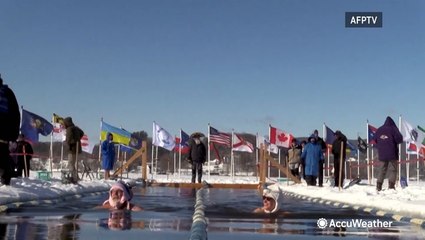 Swimmers race in the icy waters of Vermont lake