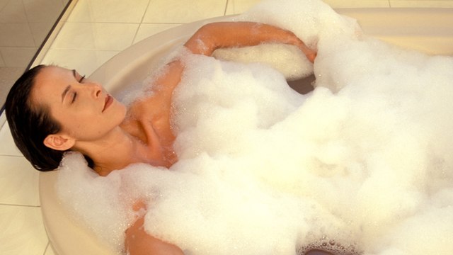 Frau entspannt in der Badewanne, doch dann bleibt sie stecken