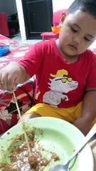 Ishaq makan sate sendiri