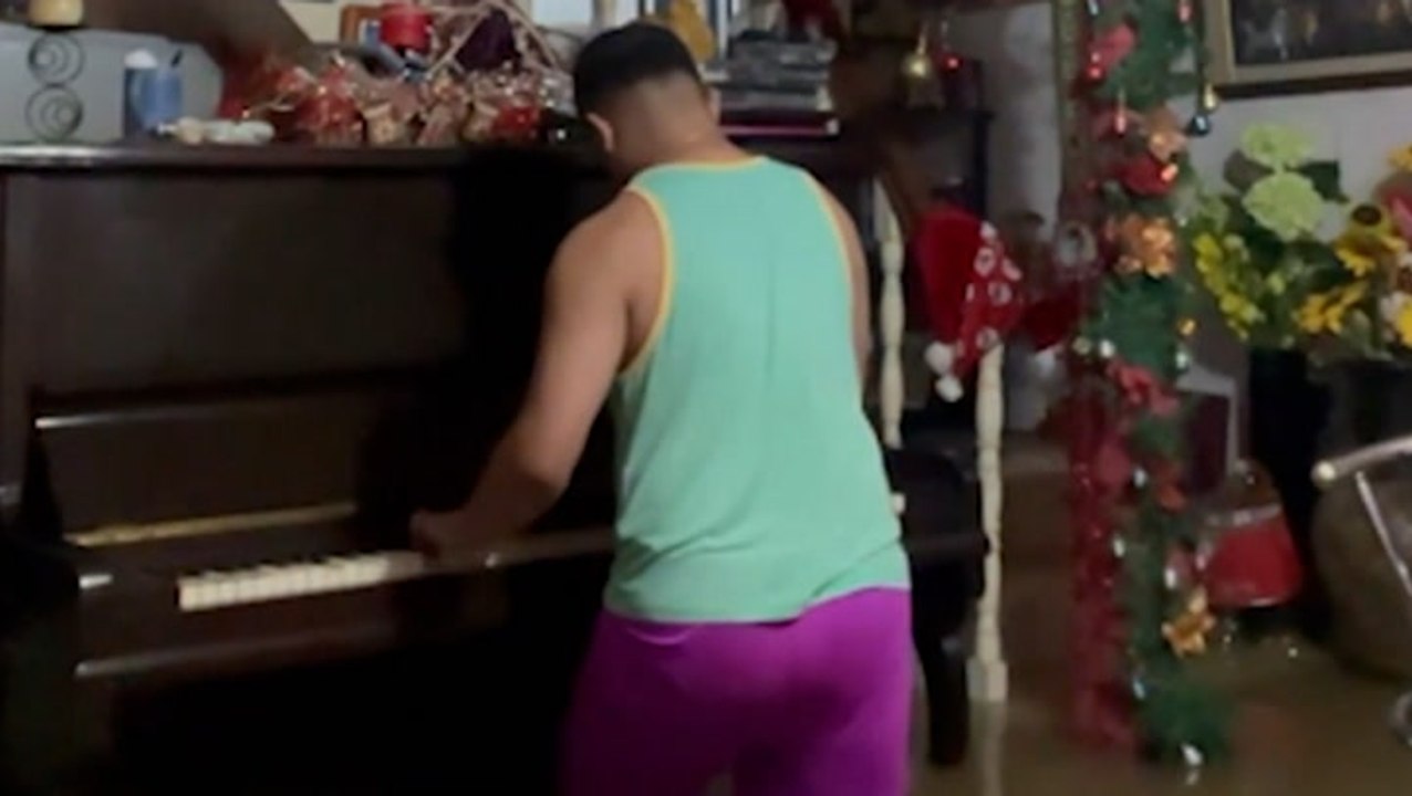 Man plays piano in flooded home