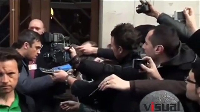 robbie williams sort d'une emission de radio et signe des autographes