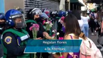 Mujeres policías reciben flores de manifestantes durante marcha del 8M