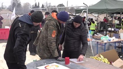 Ukrayna'dan Polonya'ya yaya olarak gelen siviller, Medyka sınır kapısında kurulan çadırlarda zaruri ihtiyaçlarını gideriyorlar