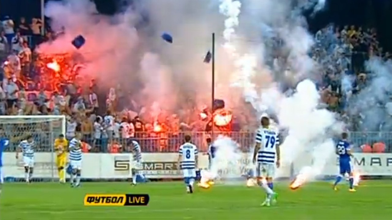 Des supporters ukrainiens jettent fumigènes et sièges sur la pelouse en plein match de football