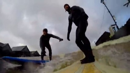 Des surfers rident en pleine ville les vagues d'une rivière déchaînée