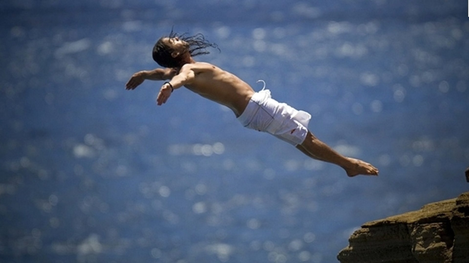 Вода падает с высоты 1200 м. Прыжок со скалы. Человек прыгает. Прыжок в воду со скалы. Красивое падение.