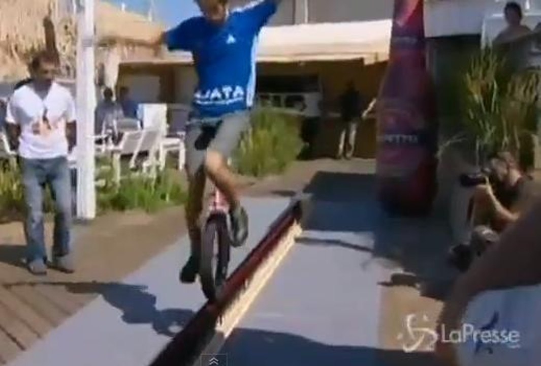 Il roule à vélo sur des bouteilles de bière