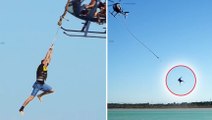 Suspendus à une corde accrochée à un hélicoptère, ils se balancent plusieurs mètres au dessus de l’eau