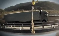 Elle fait de l'équilibre entre deux camions en marche