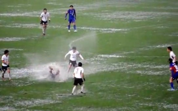Ces footballeurs japonais ne semblent pas être dérangés par ce terrain détrempé