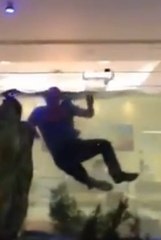 Regardez cet homme sauter dans l'aquarium rempli de poissons d'un hôtel