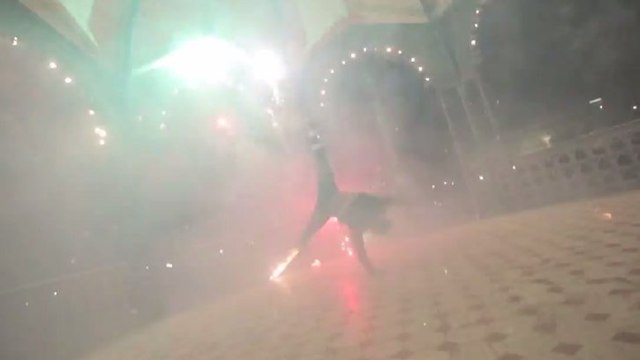 Un danseur de rue accroche des feux d'artifice à ses baskets