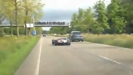 Un automobiliste filme une Formule 1 qui roule sur l'autoroute