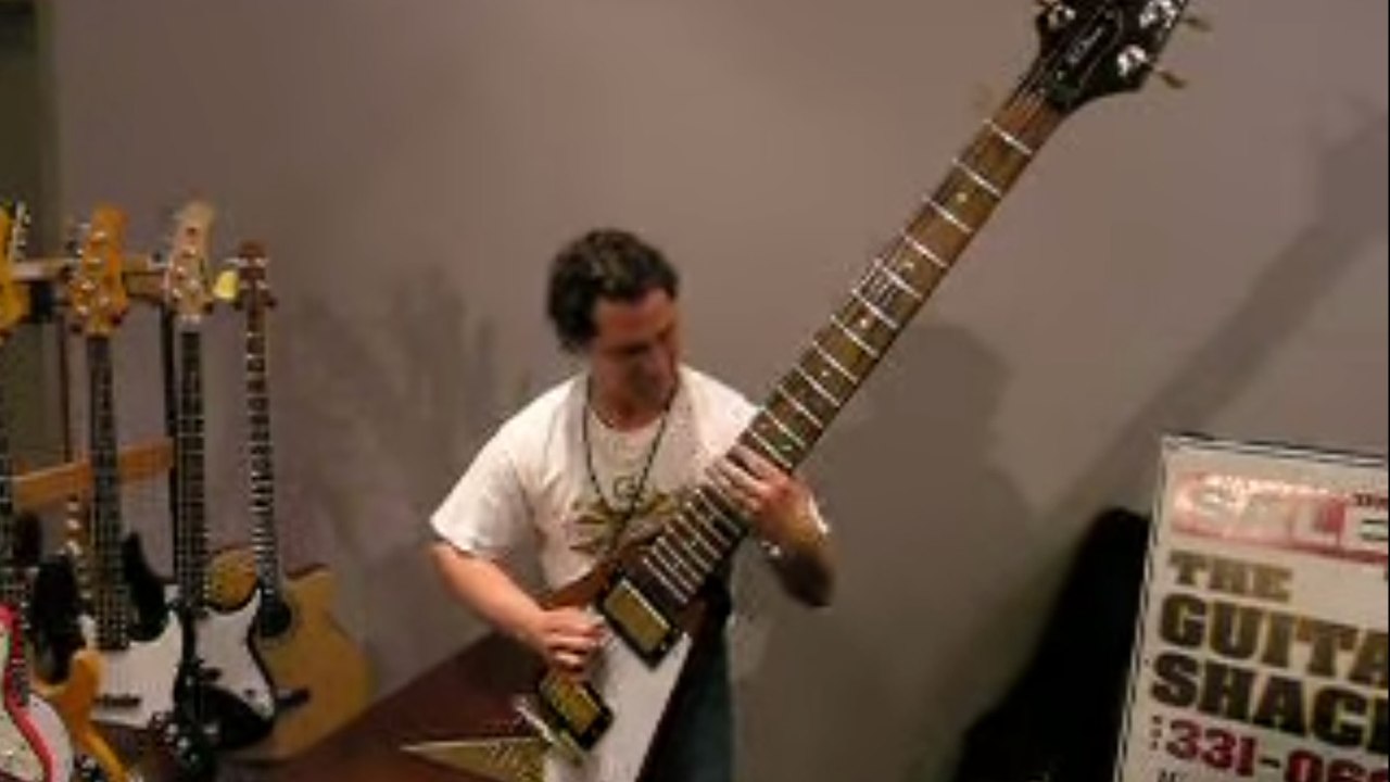 Cet homme arrive à jouer avec une guitare électrique géante !
