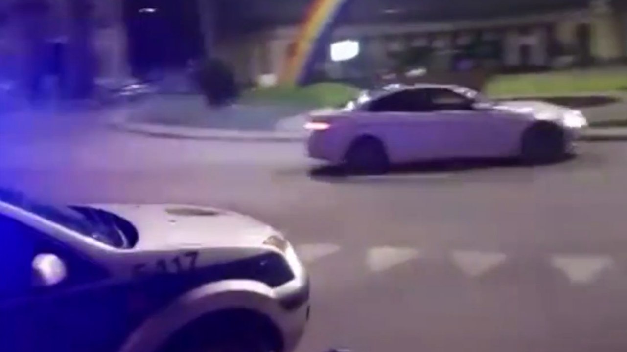 Il drifte en BMW M3 sur un rond-point et passe devant la police