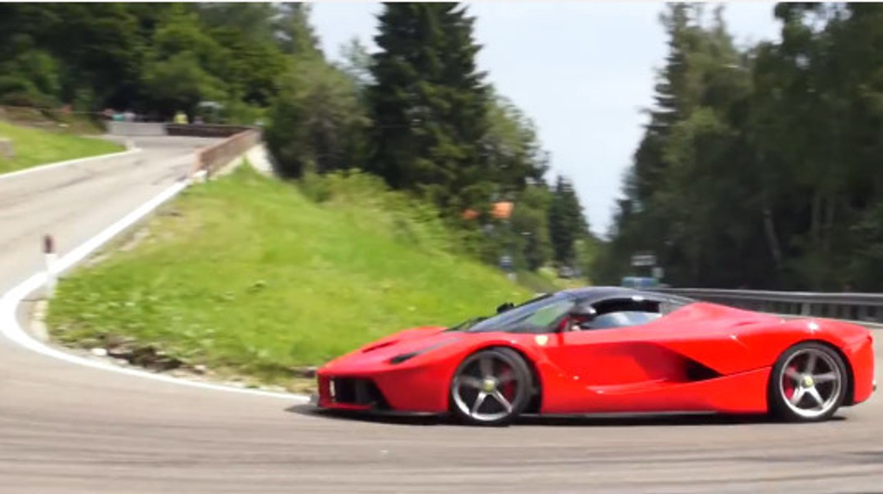 Des voitures de sport roulent à pleine vitesse sur une route de montagne