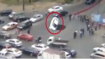 Une voiture tombe dans un énorme trou formé sur une route