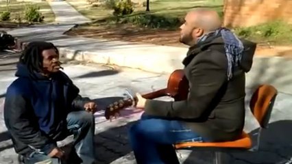 Un sans-abri chante avec un musicien
