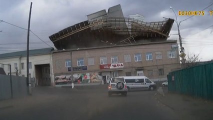 Une violente rafale de vent arrache le toit d'un bâtiment