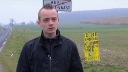 Un jeune de 20 ans installe un panneau au bord d'une route pour trouver un emploi