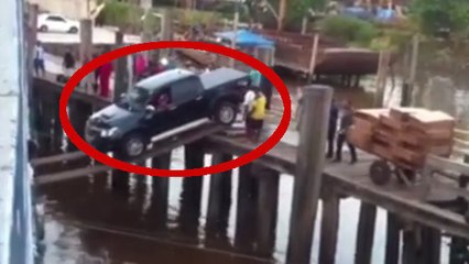 Une voiture essaie d'embarquer sur un ferry en roulant sur des planches