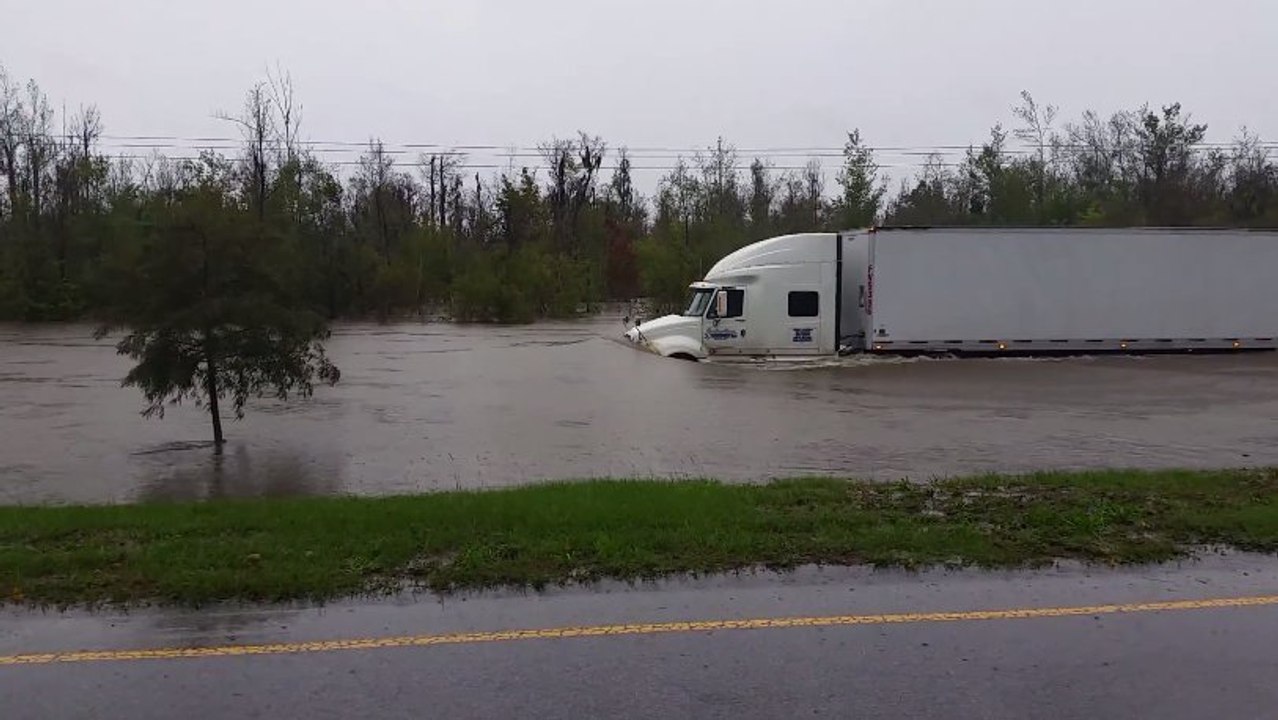 Ce camion roule sur une route inondée