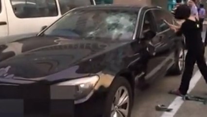 Cette femme s'acharne sur la BMW de son mari à coups de marteau