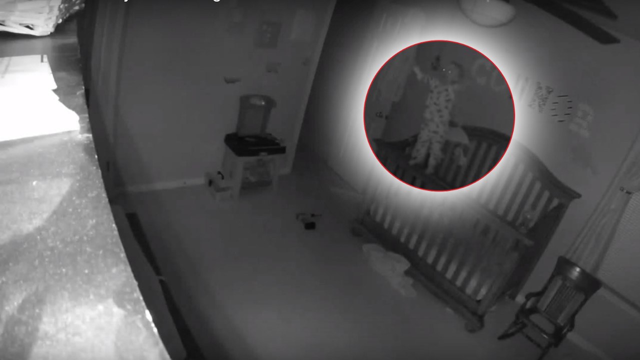 Un bébé fou se met debout sur la barrière de son lit en criant