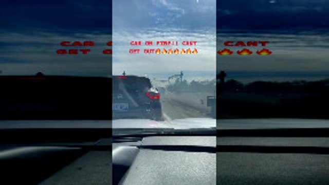 Person Drives a Car Actively on Fire Through Traffic