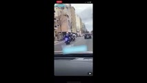 Un motard de la police pousse un scooter pour mettre fin à une course poursuite