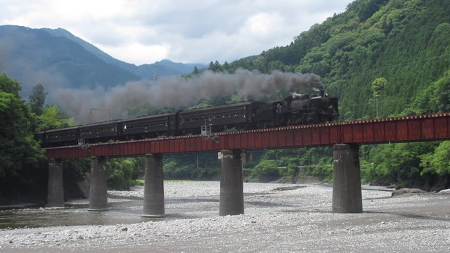 Japan Oigawa honsen steam locomotive C56-44 crosses with an excursion train the Oi river bridge in Sakidaira