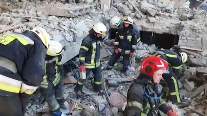 Emergency services workers dig through the rubble of missile-hit Kharkiv