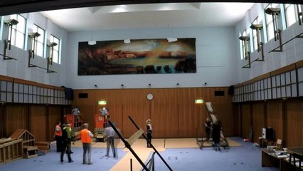 Mandy Martin's painting Red Ochre Cove being taken down temporarily at Parliament House for cleaning.