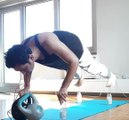 Guy Holds Weights in His Mouth and Performs Pushups While Balancing Himself Over Four Bottles