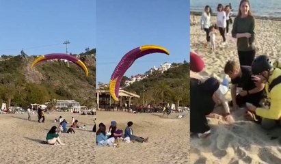 Sahile inen yamaç paraşütçüsü bir kadının üzerine düştü