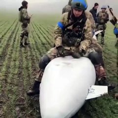 Ukrainian tips sitting for a pose for a video on a Russian unexploded bomb not so good for Russian propaganda