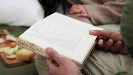 A person reading old book with other peoples