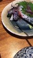 Un poisson bouge encore dans une assiette d'un restaurant japonais