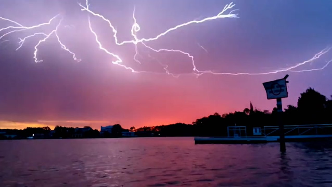 Forks of lightning stand out against a colorful Florida sunrise